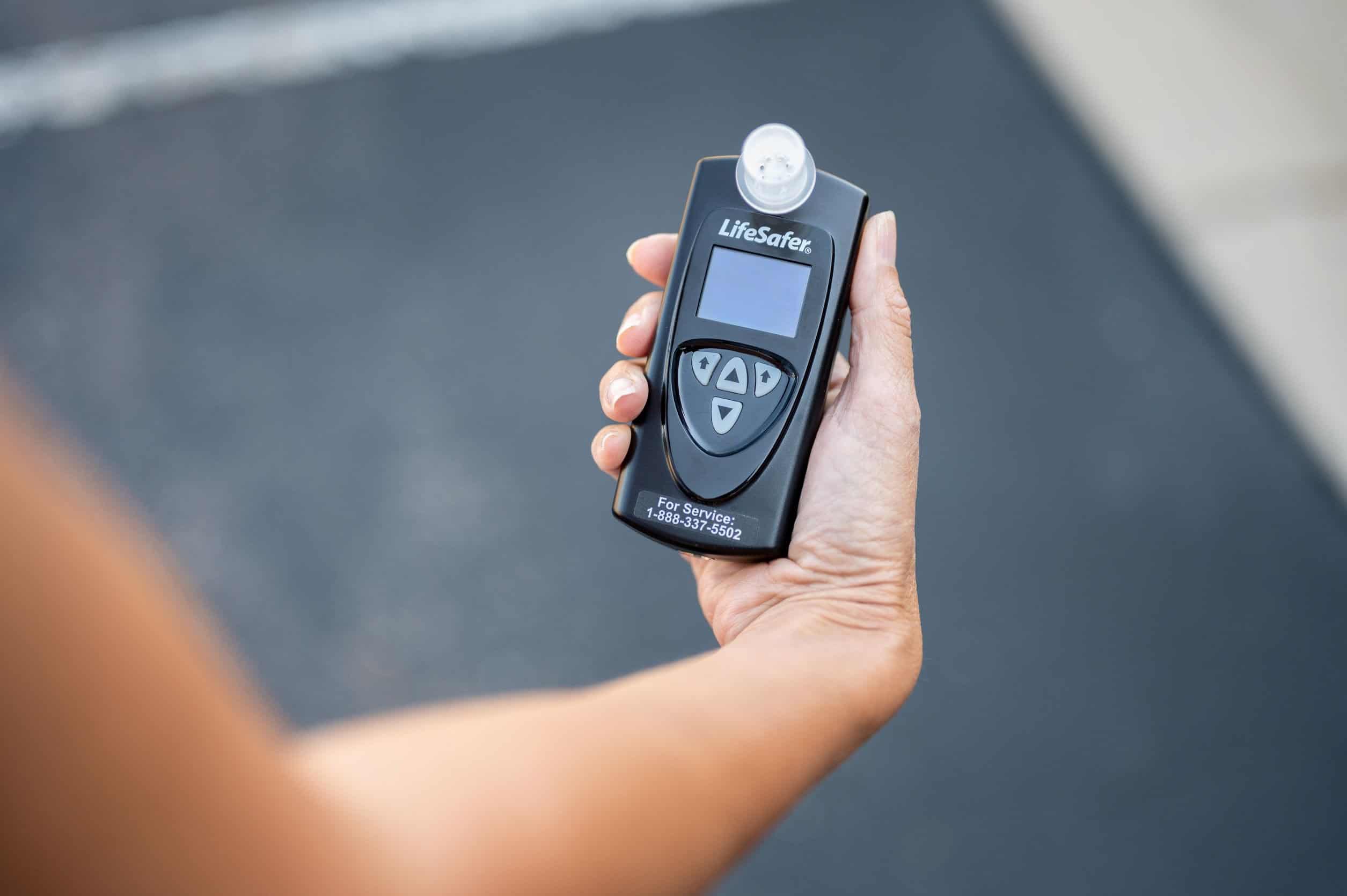 Driver using a LifeSafer ignition interlock device inside a vehicle